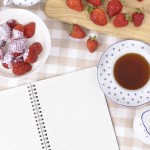 Strawberries with blank recipe book and check tablecloth